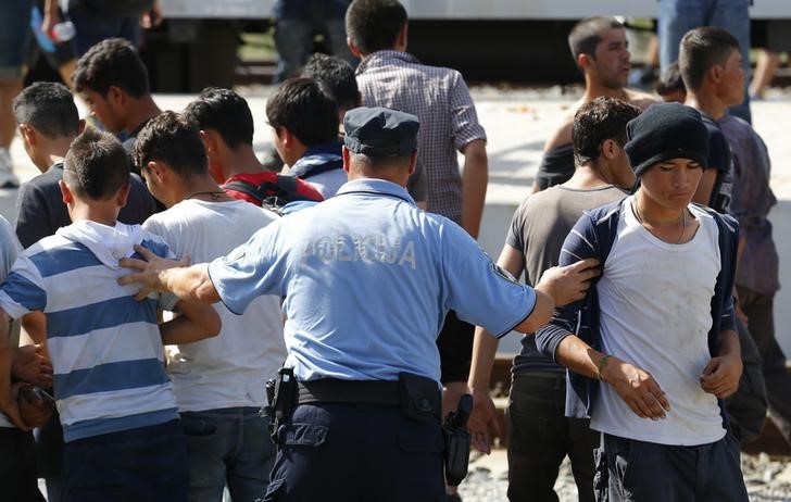 © Reuters. Policial croata afastando imigrantes na estação ferroviária em Beli Manastir, na Croácia