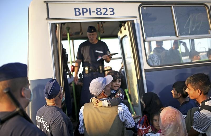 © Reuters. مئات المهاجرين يستقلون حافلات مجرية عند الحدود الكرواتية