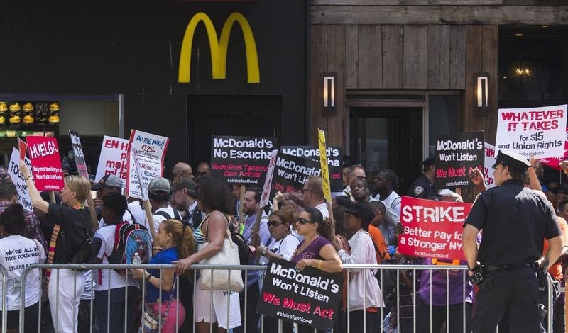 © Reuters. Activists and workers, demanding an increase in minimum wage, protest outside of a McDonald's in Manhattan, New York