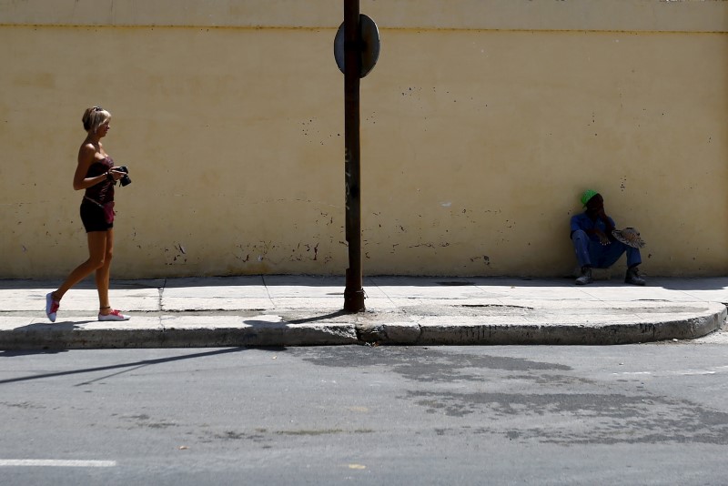 © Reuters. A tourist from Scotland walks with her camera on a street in Havana