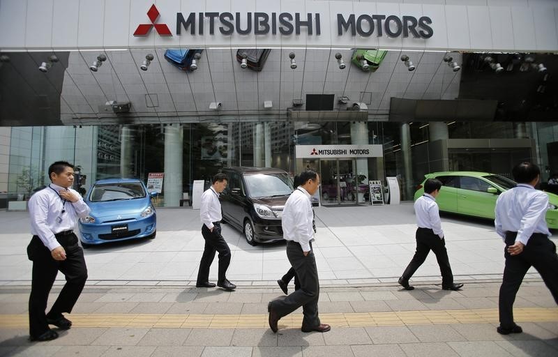 © Reuters. Men walk in front of Mitsubishi Motors Corp's headquarters in Tokyo