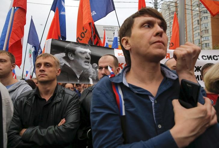 © Reuters. Opposition supporters holding a portrait of killed Kremlin critic Boris Nemtsov attend a rally in Moscow, Russia