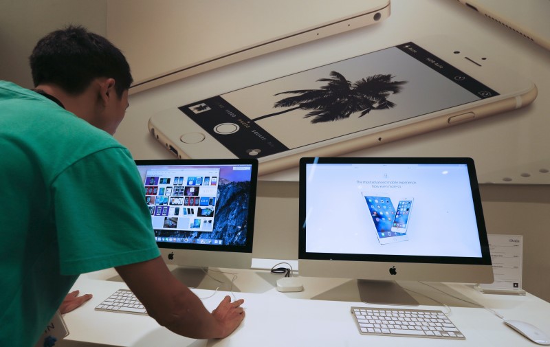 © Reuters. A sales assistant shows features of iOS 9 on an Apple iMac at an Apple reseller shop in Bangkok 