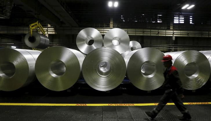 © Reuters. An employee walks past rolls of aluminum foil in a shop of the Rusal's SAYANAL foil mill outside the town of Sayanogorsk