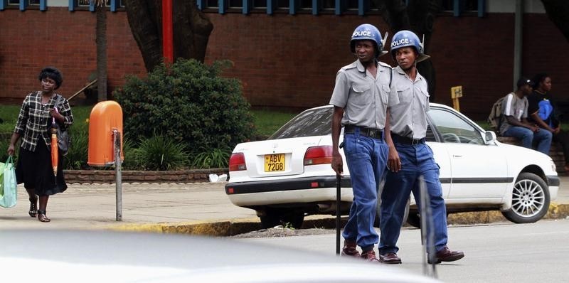 © Reuters. Zimbabwean police patrol the streets of the capital Harare