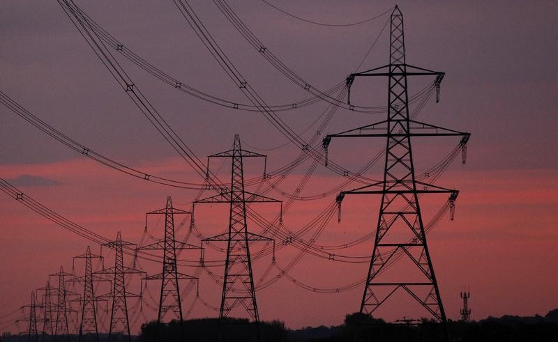 © Reuters. The sun rises behind electricity pylons near Chester