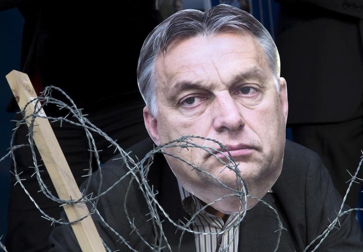 © Reuters. Ativista usando máscara do primeiro-ministro húngaro, Viktor Orban, atrás de arame farpado, em Bruxelas