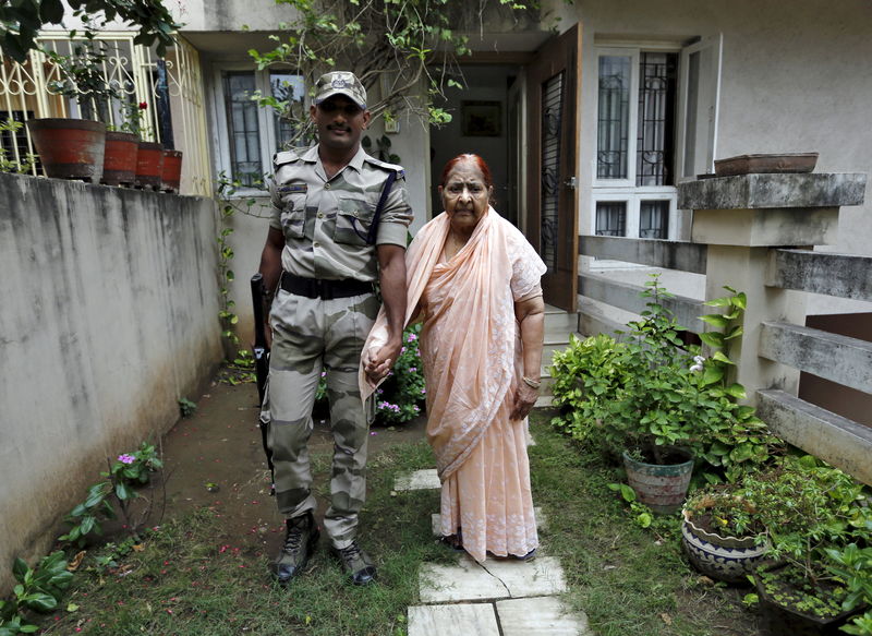 © Reuters. Zakia Jafri poses as she walks in a lawn with a security guard provided by the government at her son's house in Surat