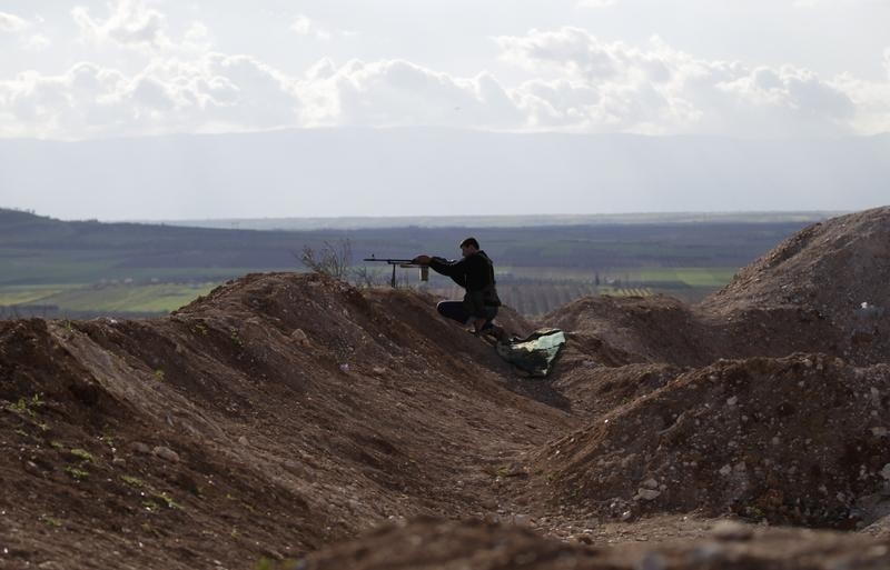 © Reuters. A rebel fighter from the Ahrar al-Sham Islamic Movement takes a position as he aims his weapon at Morek frontline in the northern countryside of Hama