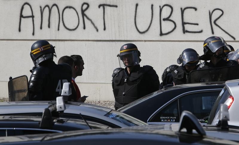 © Reuters. French riot police secure the Porte Maillot during a demonstration by French taxi drivers, who are on strike, to block the traffic on the Paris ring road during a national protest against car-sharing service Uber, in Paris