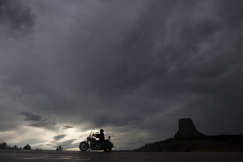 © Reuters. A motorcyclist cruises past Devils Tower National Monument