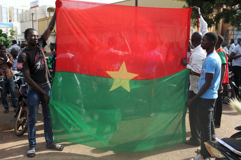 © Reuters. Anti-coup protesters hold a Burkina Faso flag in Ouagadougou