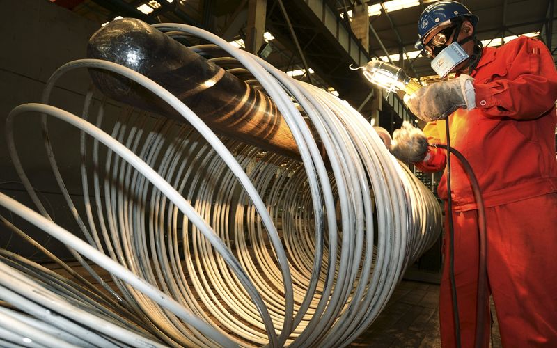 © Reuters. Worker polishes steel coils at a factory of Dongbei Special Steel Group Co., Ltd., in Dalian