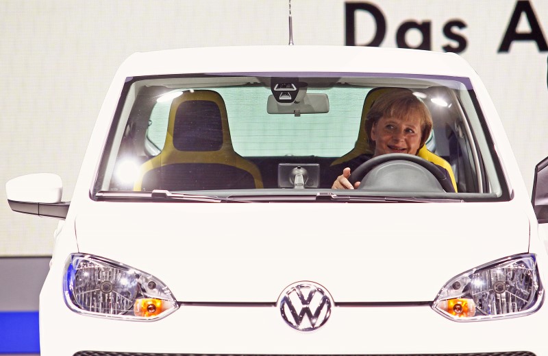 © Reuters. German Chancellor Merkel sits in a Volkswagen eco-up! auto during a visit to the International Motor Show in Frankfurt 