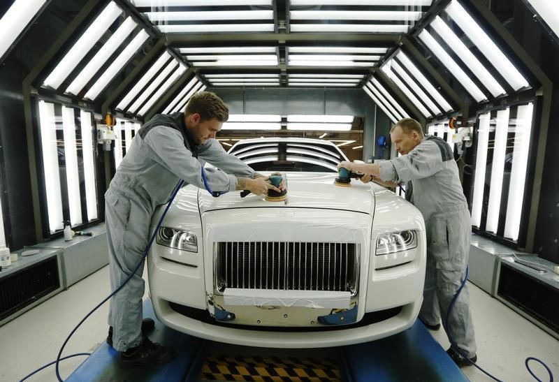 © Reuters. Employees Joe Don and Darren Lowarson give a Rolls Royce Ghost its final finish polish at the Rolls Royce Motor Cars factory at Goodwood