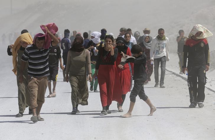 © Reuters. Displaced people from the minority Yazidi sect, who fled the violence in the Iraqi town of Sinjar, march in a demonstration at the Iraqi-Turkish border crossing in Zakho district