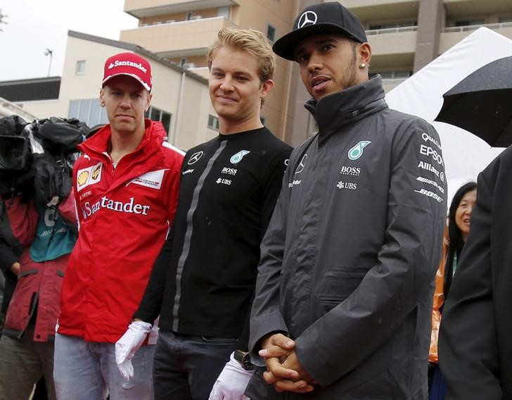 © Reuters. Pilotos da Mercedes Hamilton e Rosberg e piloto da Ferrarir Vettel durante evento em Suzuka