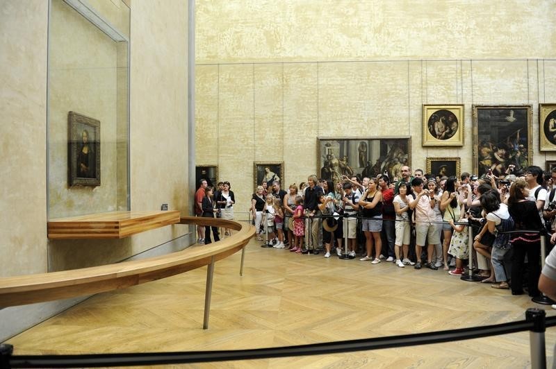 © Reuters. Turistas atrás de cordão de isolameto para observar quadro 