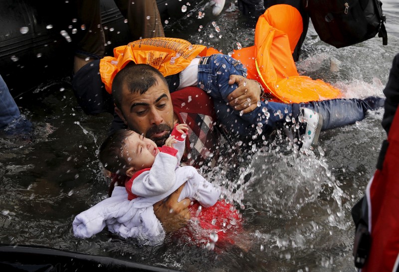 © Reuters. Refugiado sírio segundo criança ao tentar desembarcar na ilha grega de Lesbos