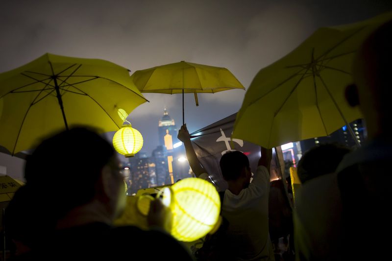 © Reuters. Pro-democracy protesters rise their yellow umbrellas as they march to the government headquarters before the first anniversary of the Occupy Central civil disobedience movement, in Hong Kong, China