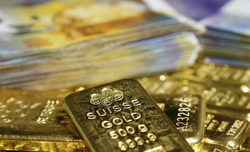 © Reuters. Gold bars and Swiss Franc banknotes are seen in this illustration picture in Vienna