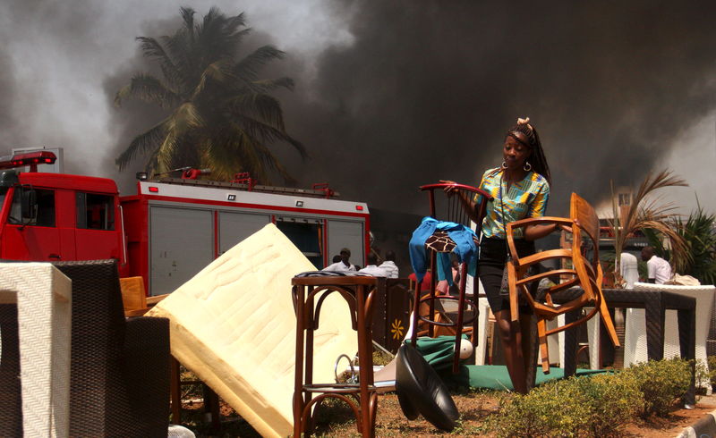 © Reuters. A worker secures furniture from the burning Chinese-owned T2000 supermarket in Burundi's capital Bujumbura