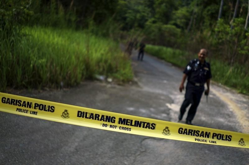 © Reuters. A Malaysian policeman leaves the site of the place where human remains were found, near an abandoned human trafficking camp, in the jungle close to the Thailand border at Bukit Wang Burma in northern Malaysia