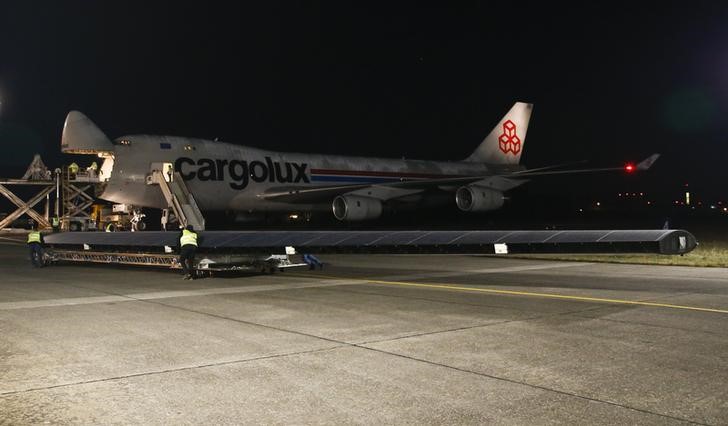 © Reuters. An element of a wing of the dismantled Solar Impulse 2 aircraft is carried towards a Cargolux Boeing 747 cargo aircraft at Payerne airport