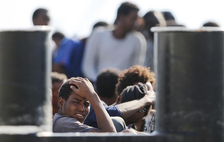 © Reuters. Migranti in arrivo nel porto di Messina 