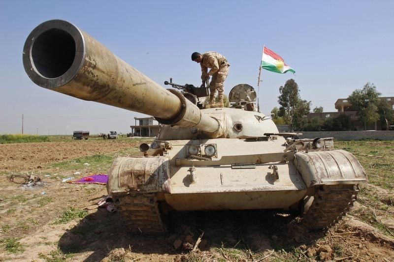 © Reuters. A member of the Kurdish peshmerga forces stands is seen atop a tank on the outskirts of Kirkuk