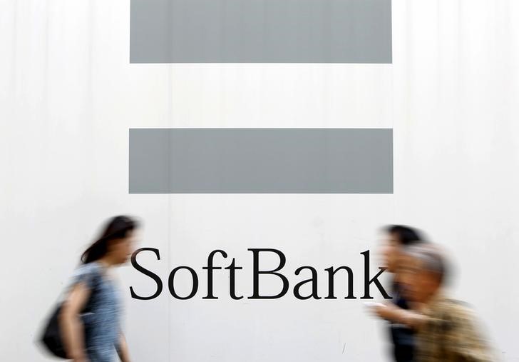 © Reuters. People walks past a logo of SoftBank Corp on a street in Tokyo