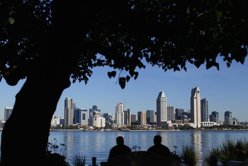 © Reuters. Two men eat their lunch while enjoying the San Diego skyline from the shoreline in Coronado