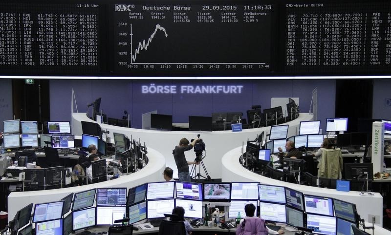 © Reuters. Traders work at screens in front of DAX board at the stock exchange in Frankfurt