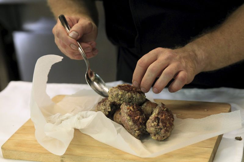 © Reuters. A chef prepares "Kibbeh", also known as Syrian meatballs, in the kitchen of the Castro restaurant in Budapest