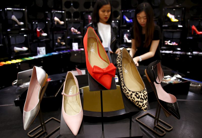 © Reuters. Carmen Dang and Gisella Velasco, both design consultants, check a display showcasing designs by Shoes of Prey located in a large department store in central Sydney, Australia