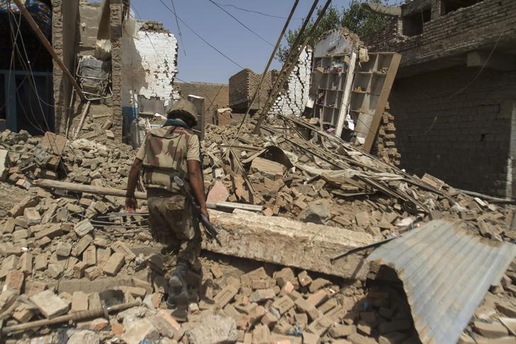 © Reuters. Soldado paquistanês em meio a casas destruídas no Waziristão do Norte