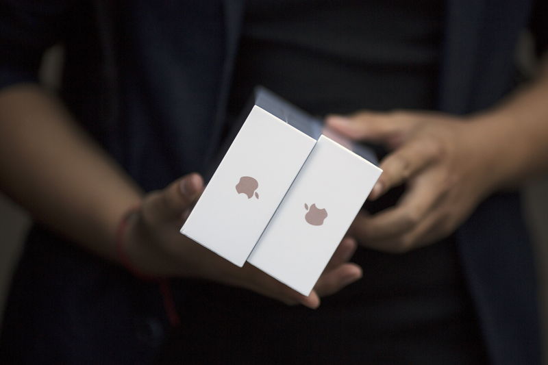 © Reuters. One of the first customers holds his phones as Apple iPhone 6s and 6s Plus go on sale at an Apple Store in Beijing