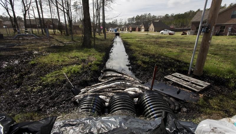 © Reuters. Spilled crude oil is seen in a drainage ditch near evacuated homes near Starlite Road in Mayflower