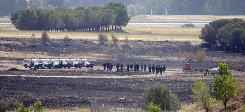 © Reuters. File photo of Spanish civil guards patroling the crash site of the Spanair jet crash at Barajas airport in Madrid