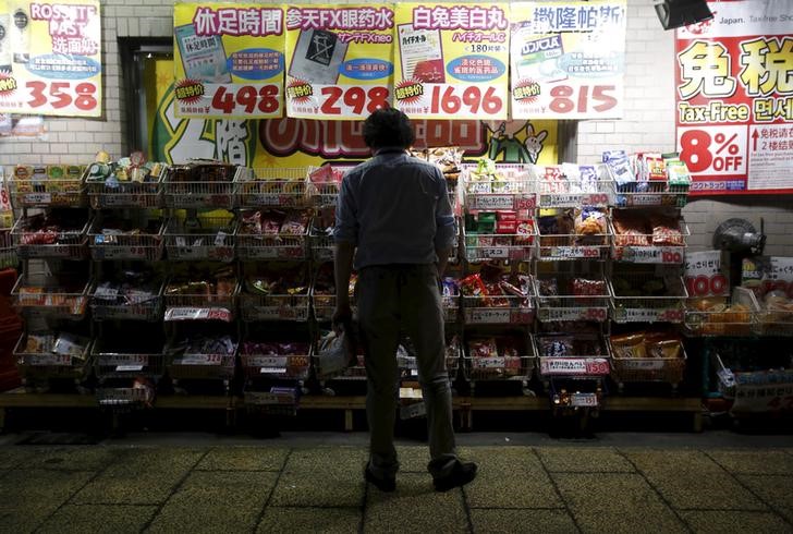 © Reuters. A man looks at an item outside a discount drug store at a shopping district in Tokyo