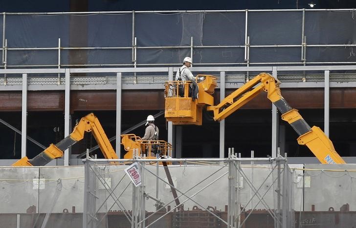 © Reuters. Men work on lifts at a construction site in Tokyo