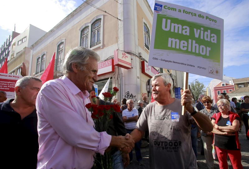 © Reuters. Jeronimo de Sousa, leader of the Portuguese Communist Party, shakes hands with a supporter during an election campaign event in Barreiro, Portugal 