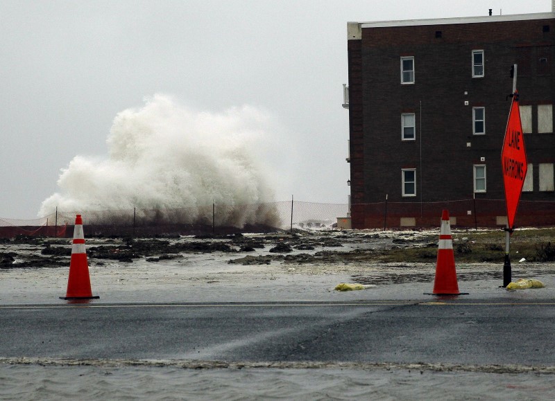 © Reuters. Waves crash against the sea wall in front of an apartment building as a norâ??easter comes on shore in Atlantic City
