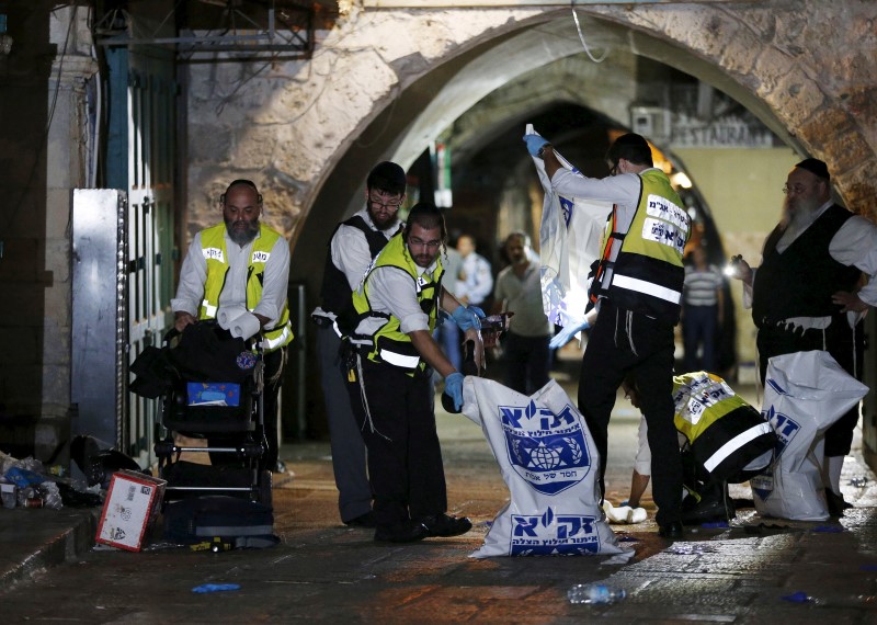 © Reuters. Members of the Zaka Rescue and Recovery team clean the scene where a Palestinian was shot dead after he stabbed and killed two people in Jerusalem's Old City