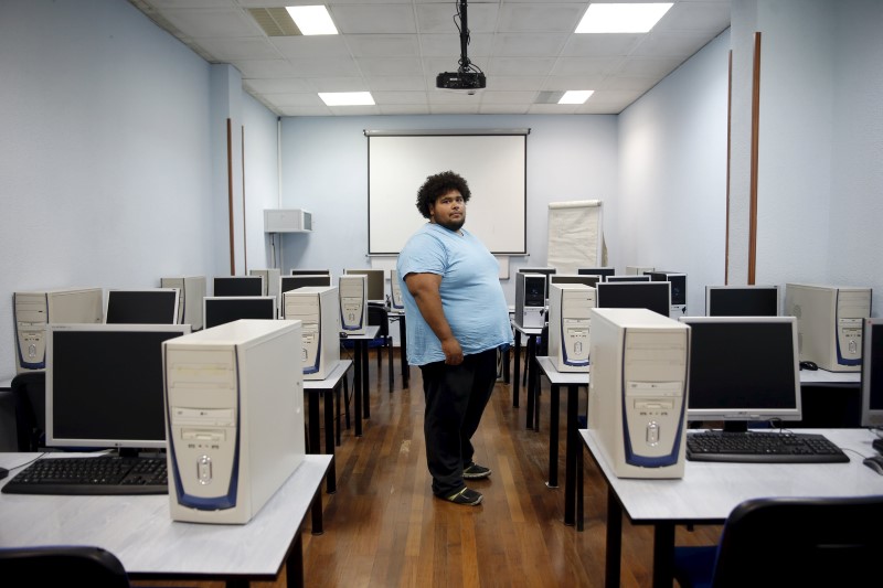 © Reuters. Kelvin Heredia poses for a picture at the academy where he's taking a computer course in Mostoles, outside Madrid