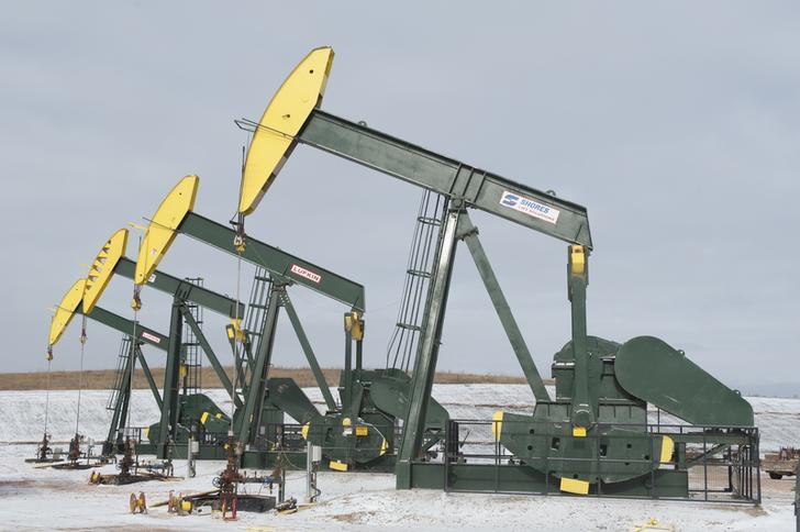 © Reuters. Pumpjacks taken out of production temporarily stand idle at a Hess site while new wells are fracked near Williston