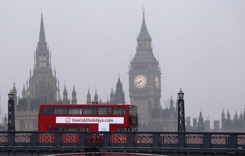 © Reuters. A bus crosses Lambeth Bridge past the Houses of Parliament in London