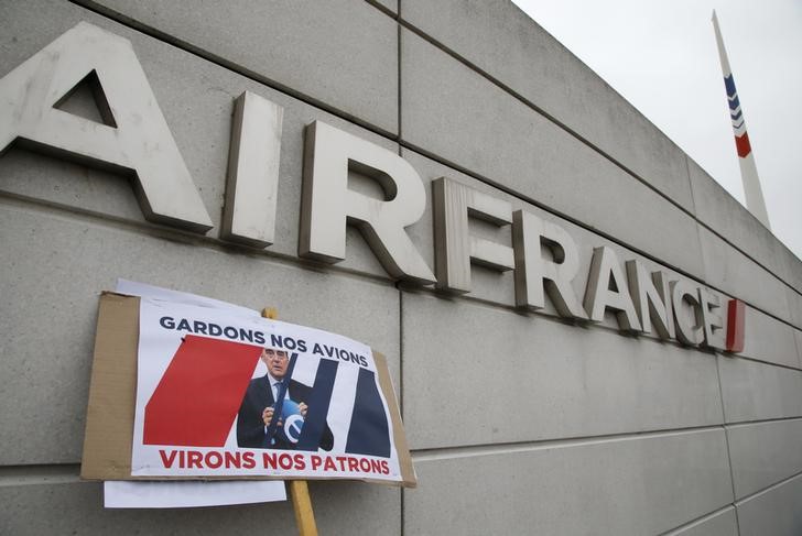 © Reuters. A board with an image of Air France-KLM Chief Executive Officer Alexandre de Juniac reading "keep our planes, sack the bosses" is seen on the Air France headquarters building at the Charles de Gaulle International Airport in Roissy