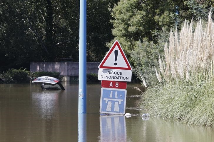 © Reuters. Placa indicando risco de inundação do lado de pedaço de carro, em Mandelieu, na França