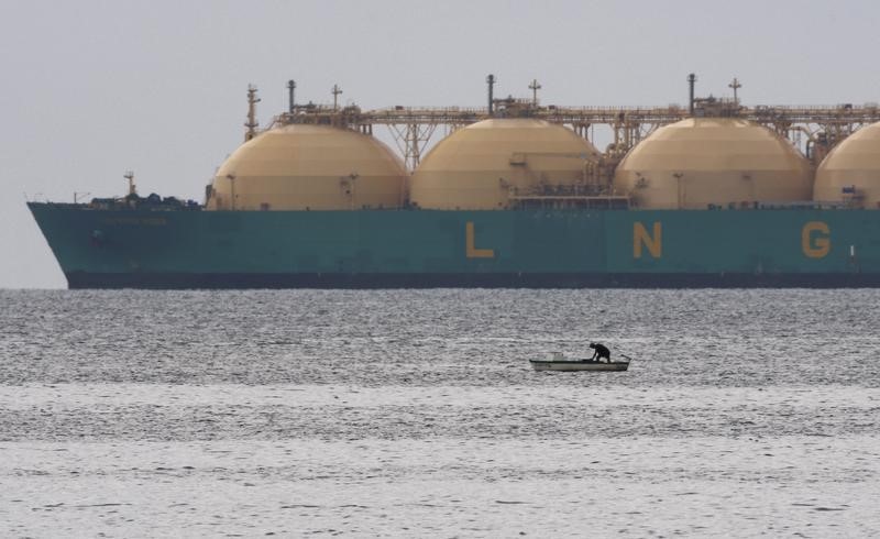 © Reuters. Рыбак на фоне СПГ-танкера близ Гаваны